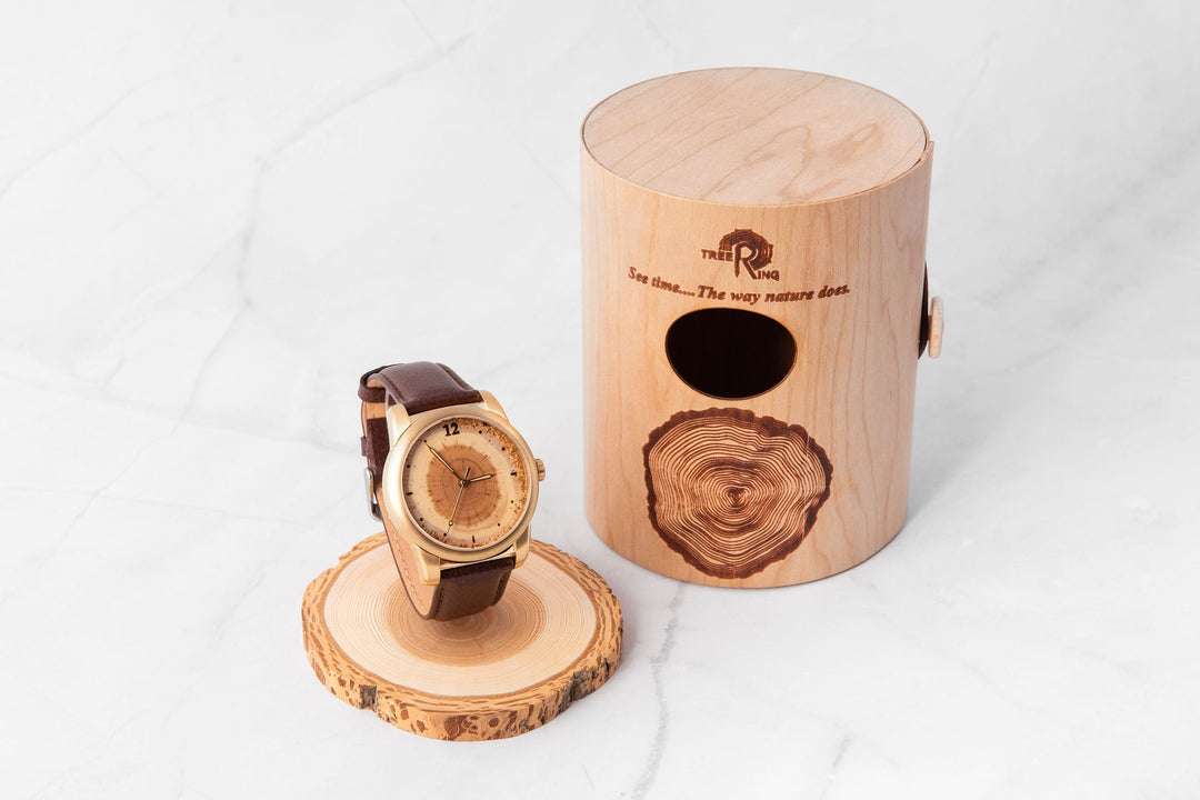 Tree Ring Memorial Pet Watch beside a wooden storage box, honoring pets with a cremation ash compartment.