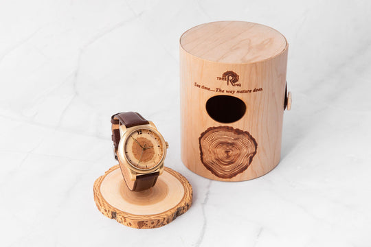 Tree Ring Memorial Pet Watch beside a wooden storage box, honoring pets with a cremation ash compartment.