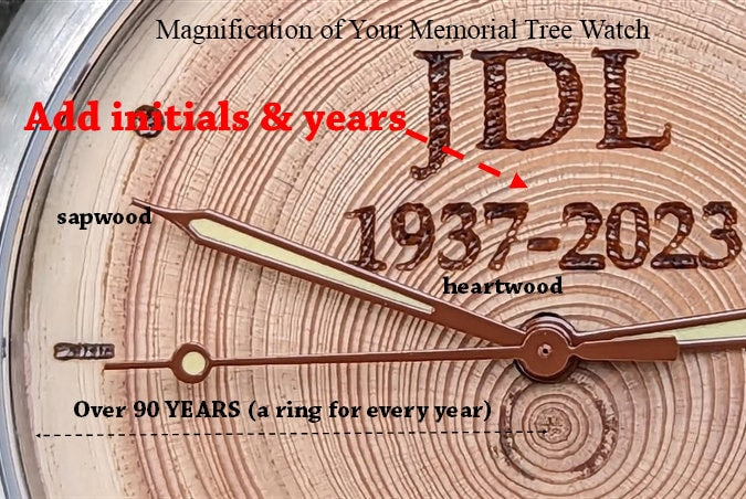 Close-up of a memorial tree watch face with initials JDL and years 1937-2023, highlighting tree rings for remembrance.