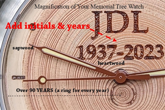 Close-up of a memorial tree watch face with initials JDL and years 1937-2023, highlighting tree rings for remembrance.